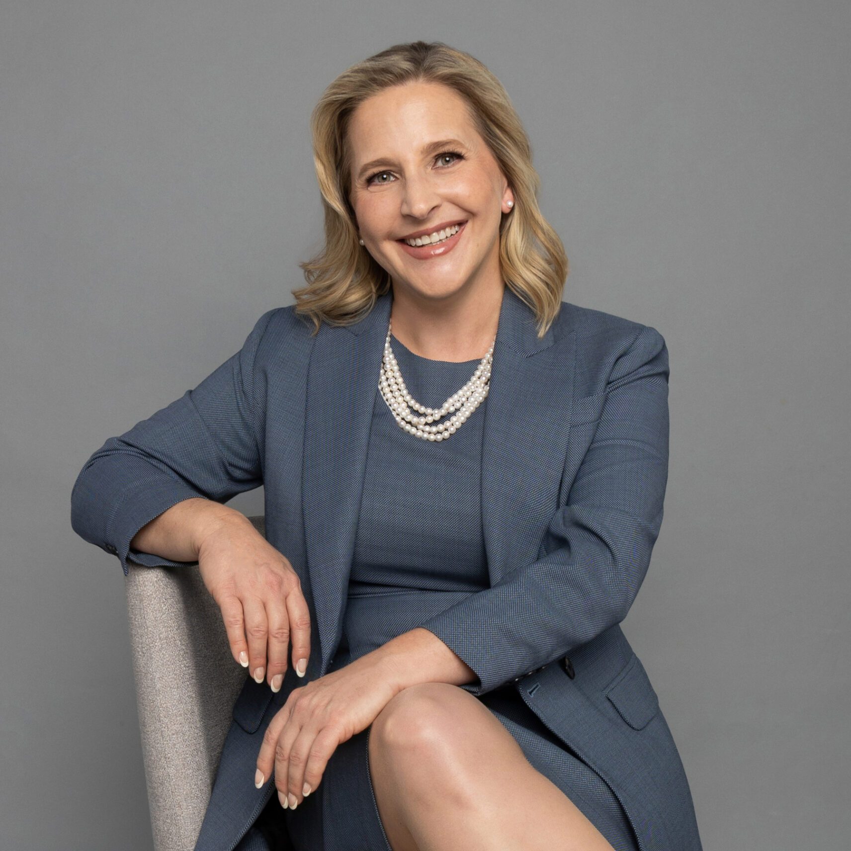 Smiling Amy Foust in professional attire seated confidently.